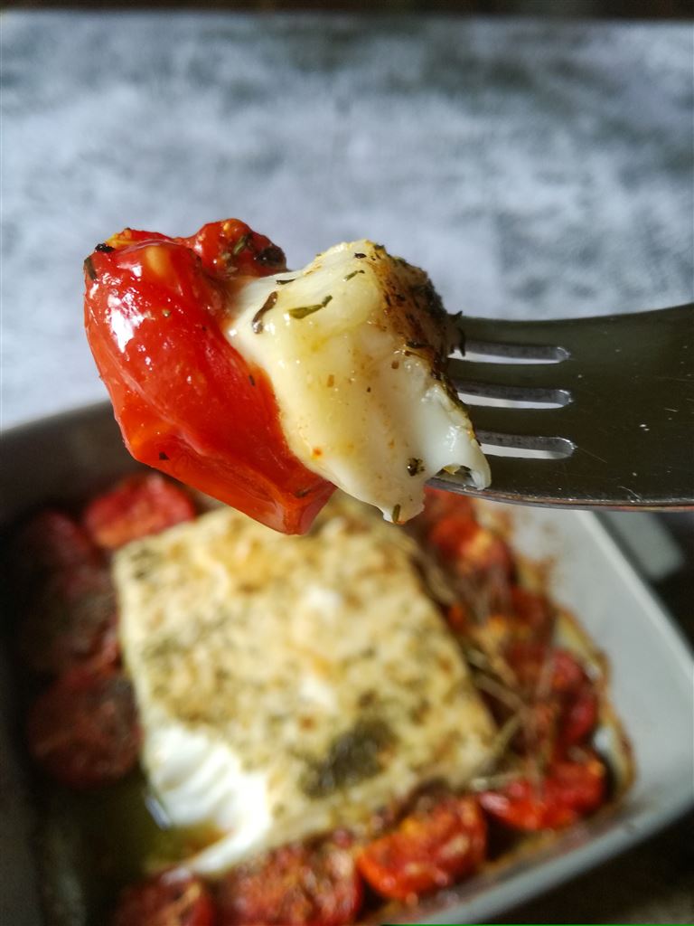 Eine Gabel mit schmelzendem veganen Ofenfeta und Tomate
